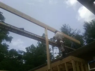 Carpenter setting a ridge beam over a new addition frame — Ice Dam Removal by Roofing Brothers in Courtland